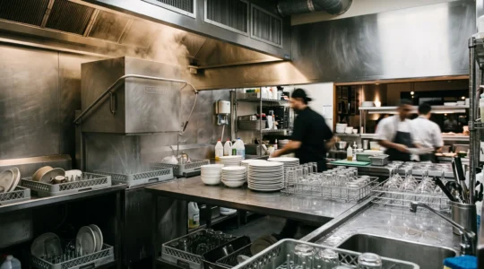 Poste de plonge professionnel organise dans une cuisine de restaurant pendant le service